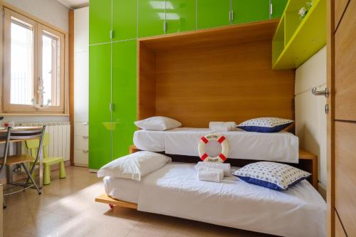 three beds in a room with a green wall at Affaccio Sul Mare Luxury Home in Porto Cesareo
