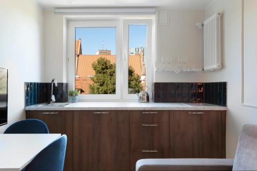 a kitchen with a sink and a window at Elite Apartments Old Town Podwale Classy in Gdańsk