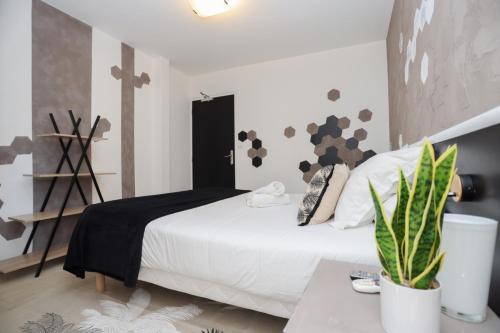 a bedroom with a white bed and a plant at Hostellerie LE PANEL in Mandelieu-la-Napoule