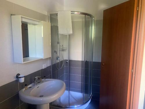 La salle de bains est pourvue d'un lavabo et d'une douche en verre. dans l'établissement B&B La Torretta, à Gasponi