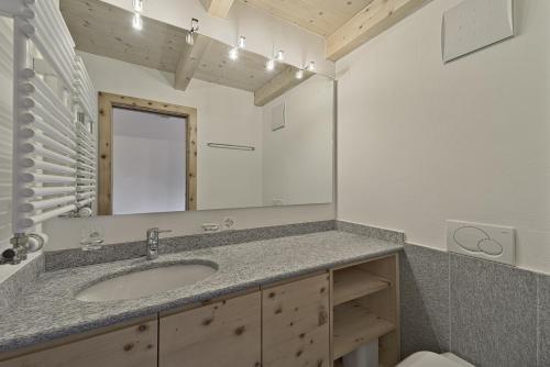a bathroom with a sink and a mirror at Chesa Piz Chalchagn - Pontresina in Pontresina