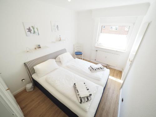 ein kleines Schlafzimmer mit 2 Betten und einem Fenster in der Unterkunft Appartement 36 in Westerland