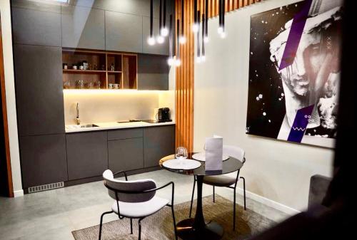 a dining room with a table and chairs and a kitchen at Apart Hotel на Трояндовой in Chernivtsi