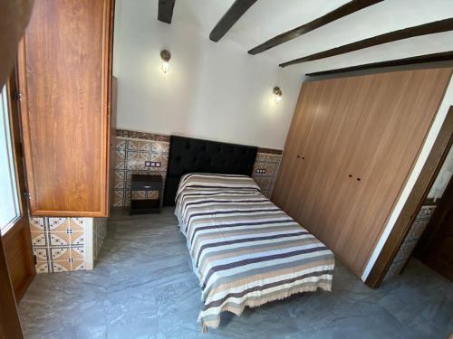 Cette chambre comprend un grand lit et des placards en bois. dans l'établissement La carchata 1, à Siete Aguas