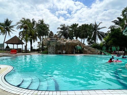 uma grande piscina com pessoas na água em Glory Beach Resort em Porto Dickson