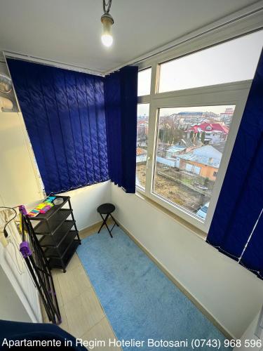 an empty room with blue curtains and a window at Apartament Uvertura Mall/Lidl cu parcare gratuita in Botoşani