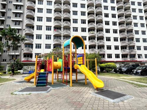 um parque infantil em frente a um grande edifício em Glory Beach Resort em Porto Dickson
