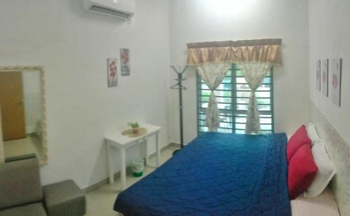 ein Schlafzimmer mit einem blauen Bett und einem Fenster in der Unterkunft Homestay Lestari KLIA in Sepang