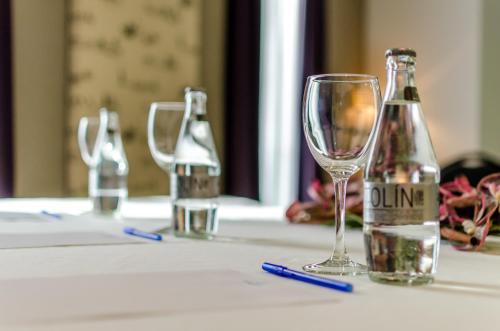 a table with two bottles and a wine glass at YIT Vía Sevilla Mairena in Mairena del Aljarafe