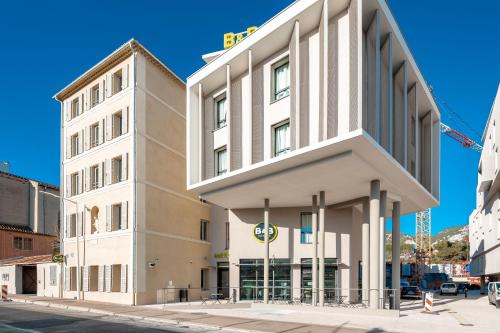 ein großes weißes Gebäude an der Ecke einer Straße in der Unterkunft B&B HOTEL Toulon Centre Gare in Toulon