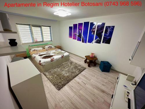 a bedroom with a bed and pictures on the wall at Apartament Uvertura Mall/Lidl cu parcare gratuita in Botoşani