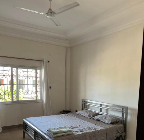 biała sypialnia z łóżkiem i oknem w obiekcie Laffie House w mieście Sukuta
