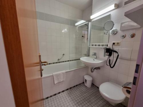 ein Badezimmer mit einem Waschbecken, einem WC und einem Spiegel in der Unterkunft ciao-aschau Haus zur Burg Apn21 Krämer in Aschau