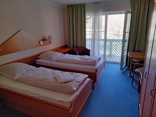 a hotel room with two beds and a balcony at ciao-aschau Haus zur Burg Apn220 Mina in Aschau