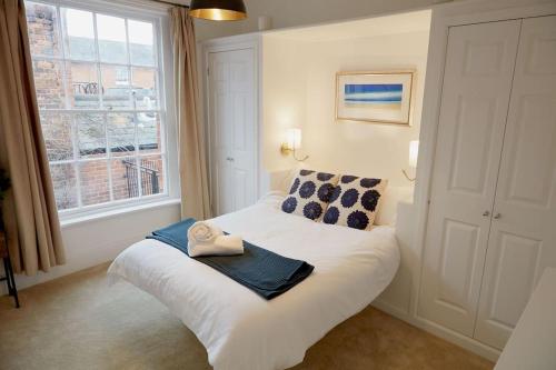 a bedroom with a bed with a towel on it at Duck Cottage in the centre of Henley in Henley on Thames