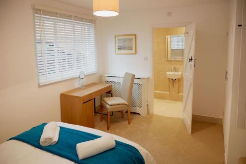a bedroom with a bed and a desk and a sink at Duck Cottage in the centre of Henley in Henley on Thames