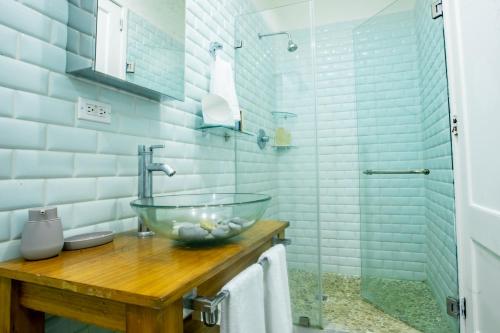 a bathroom with a glass bowl sink on a wooden counter at Villa #17 - Blue Venao, Playa Venao in Playa Venao