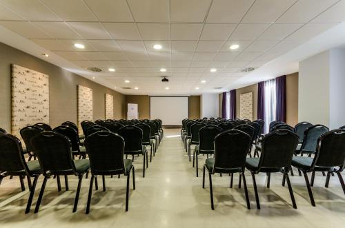 an empty room with chairs and a projection screen at YIT Vía Sevilla Mairena in Mairena del Aljarafe