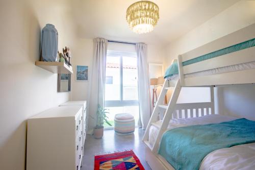 a bedroom with a bunk bed and a chandelier at Villa #17 - Blue Venao, Playa Venao in Playa Venao