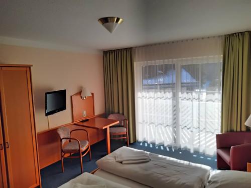 um quarto de hotel com uma cama, uma secretária e uma janela em ciao-aschau Haus zur Burg Apn233 Julia em Aschau