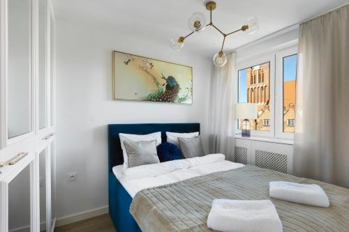 a white and blue bedroom with a bed at Elite Apartments Old Town Podwale Classy in Gdańsk