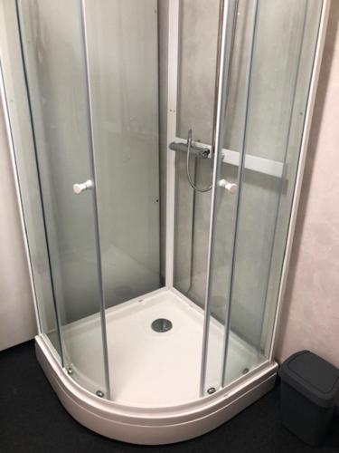 a shower with a glass door in a bathroom at Viivin tuvat C in Rantatöysä