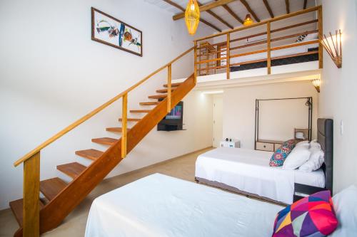 a bedroom with two beds and a staircase at Pousada Morada Do Sol in Arraial d'Ajuda