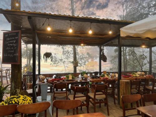 um restaurante com mesas e cadeiras e vista para um campo em Gió bungalow em Sa Pa