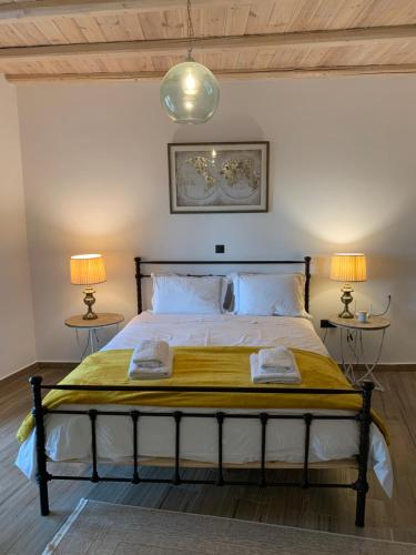 a bedroom with a large bed with two lamps at The Mousehouse in Áno Rínglia