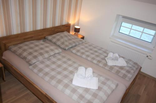 two beds with white shoes on them in a bedroom at Kleinheide 2 in Berumbur