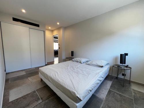- une chambre avec un lit blanc et une télévision dans l'établissement T3 avec terrasse, Centre Ville Lavandou, au Lavandou