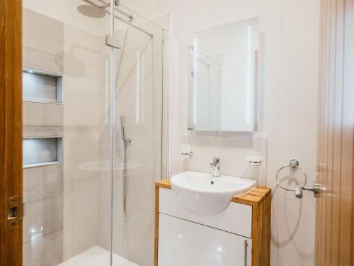 a white bathroom with a sink and a shower at Bluebell Lodge in Skipton
