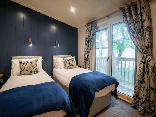 two beds in a room with a window at Bluebell Lodge in Skipton