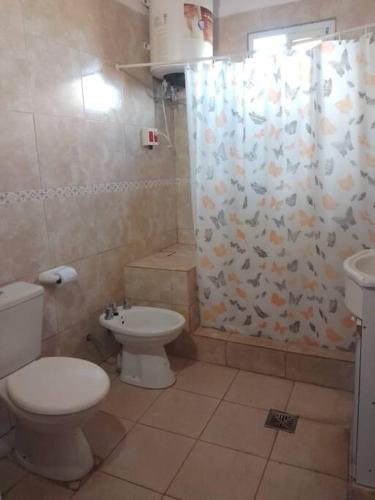 La salle de bains est pourvue de toilettes et d'un rideau de douche. dans l'établissement Casa en la Colonia - PetFriendly, à Concepción del Uruguay