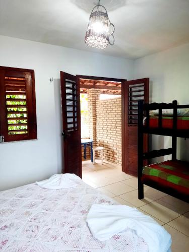 a bedroom with a bed and a open door at Pousada dos Anjos Paracuru in Paracuru