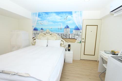 a bedroom with a white bed with a view of the ocean at Sea Keelung in Keelung