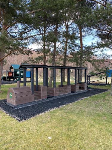 a park with a bus stop in the grass at Scandinavian Village Ltd in Aviemore