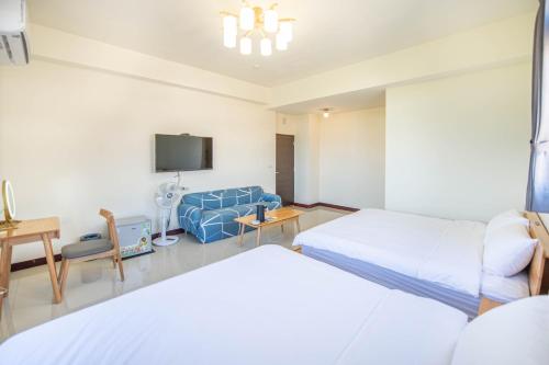 ein Hotelzimmer mit 2 Betten und einem TV in der Unterkunft 別野城北 in Hsing-wen