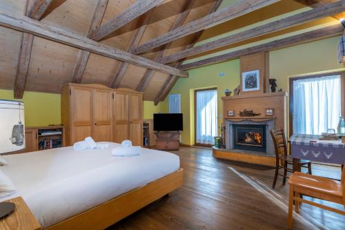 a bedroom with a large bed and a fireplace at Valbruna Inn Bed & Breakfast in Valbruna
