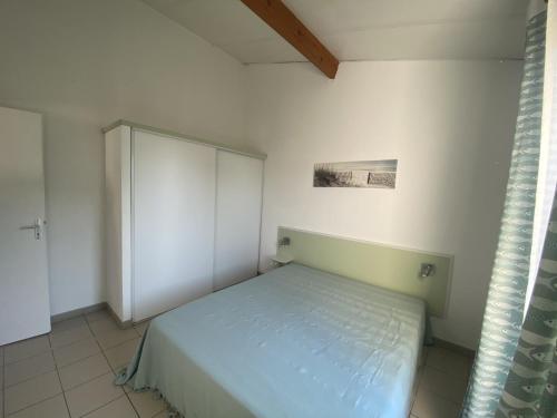 a small bedroom with a bed and a cabinet at 52amareyeurs in Le Château-dʼOléron