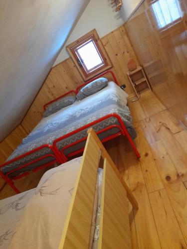 a bed in a room with a wooden floor at Residenze Ca del bosco Piancavallo in Piancavallo