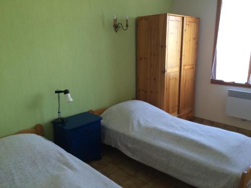 1 dormitorio con 2 camas, armario y ventana en Sejour relaxant a Grand-Village, en Grand-Village-Plage