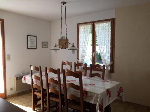 Un comedor con mesa y sillas y una ventana. en Sejour relaxant a Grand-Village, en Grand-Village-Plage