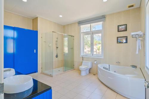 ein Badezimmer mit einer Badewanne, einem WC und einem Waschbecken in der Unterkunft Casa Villa - Floral Park- Sealinks City Resort in Phan Thiet