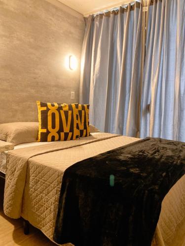 a bedroom with a large bed and a window at LOFT BC in Balneário Camboriú