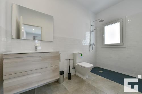 een badkamer met een toilet, een wastafel en een spiegel bij Villa Marigold - Grupo Turis in Benissa