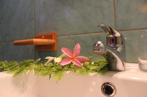 a bathroom sink with a faucet with flowers on it at Chez Jérôme in Hanga Roa