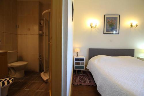 a bedroom with a bed and a bathroom with a toilet at Les Gagères in Puligny-Montrachet