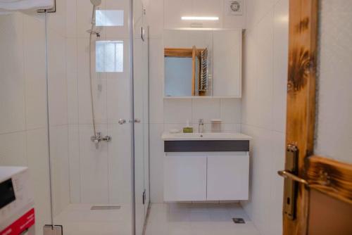 a white bathroom with a shower and a sink at Waterfront Terrace House Bosphorus Istanbul in Istanbul