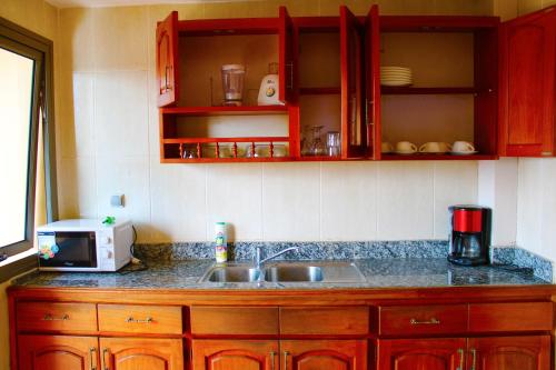 a kitchen counter with a sink and a microwave at Residence Le Carat Silverline in Douala